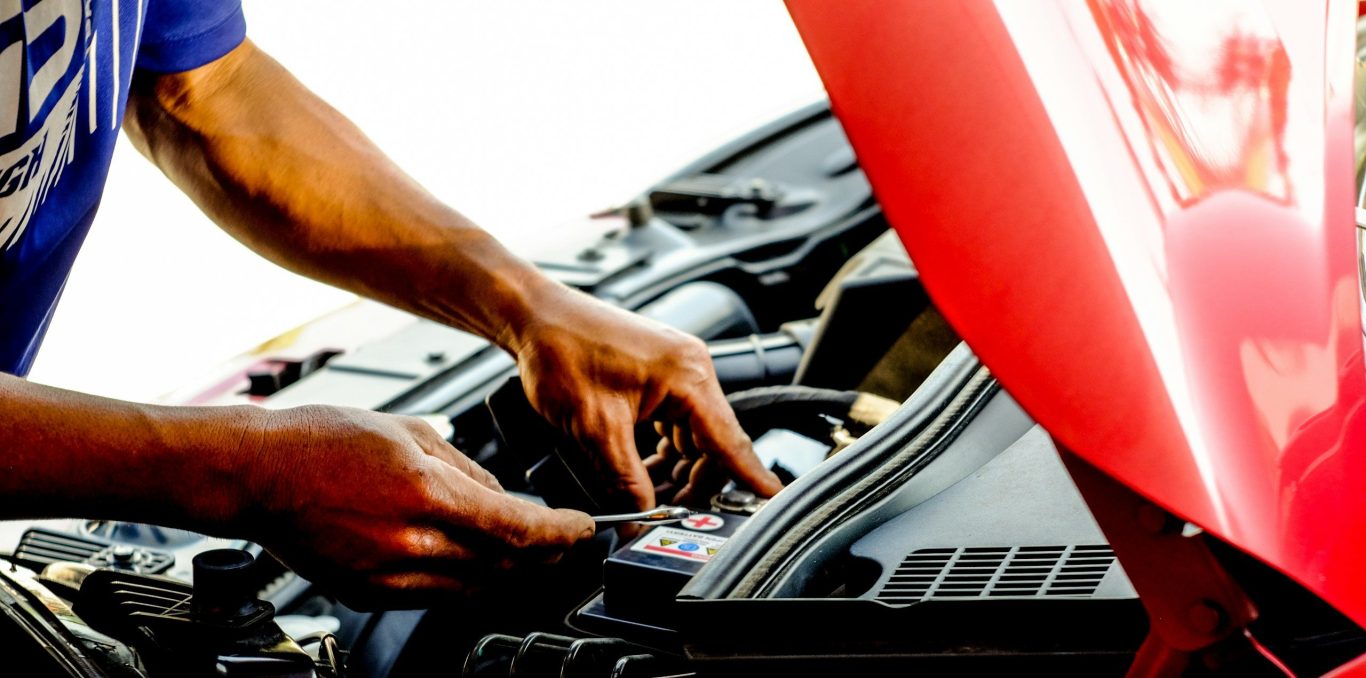 Hands working in a vehicle engine bay